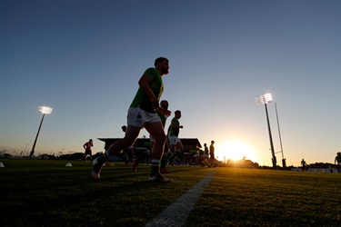 Sunset behind the stadium with players on field 